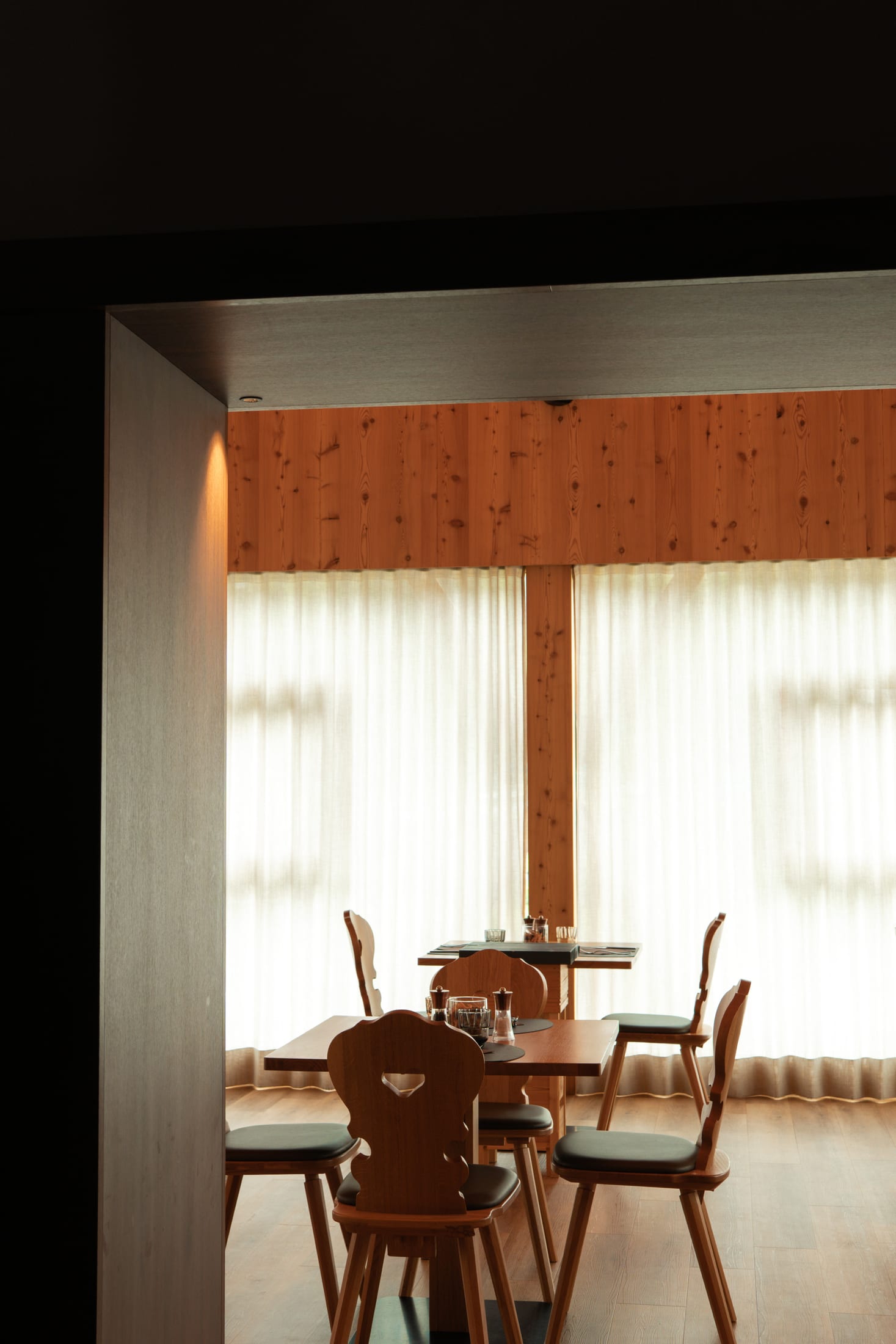 Sala de La Raisc in legno di larice con luce calda